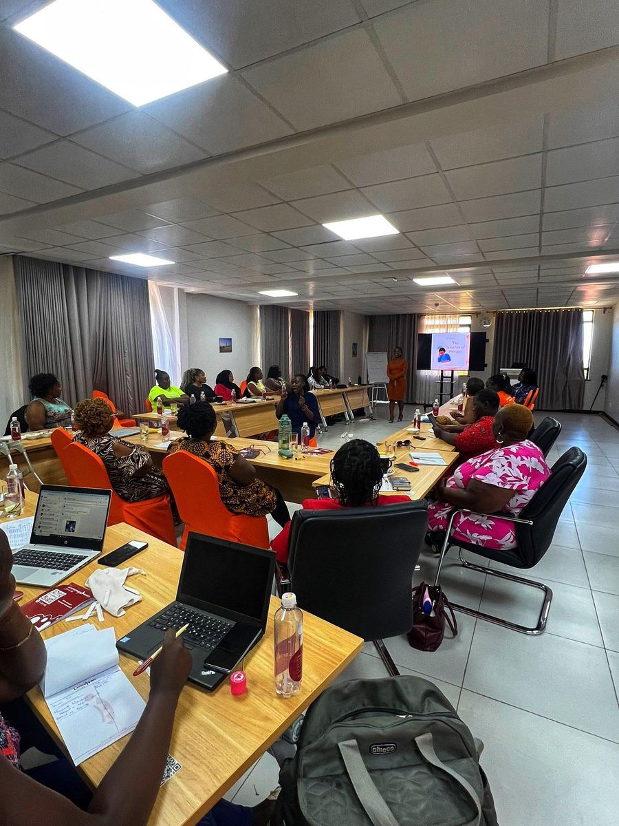 Participants seated at tables with laptops during a training session