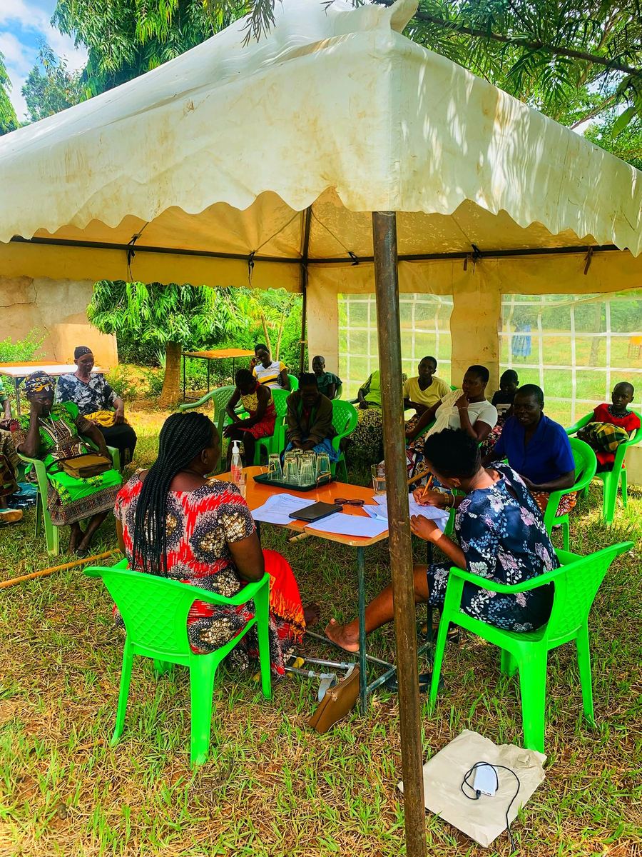 Women working together at tables under an outdoor tent
